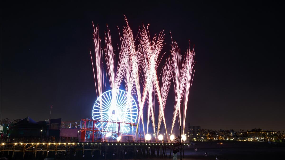 Fireworks are set off as people gather to celebrate "Lights On, " an event marking it's 20th birthday celebration of Santa Monica Pier's Pacific Park.
