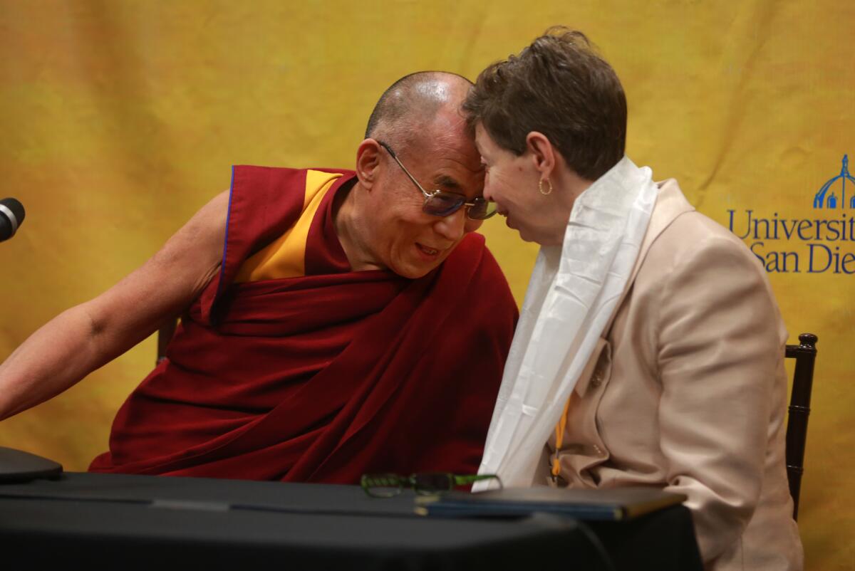 The Dalai Lama connects foreheads with Chancellor Marye Anne Fox.