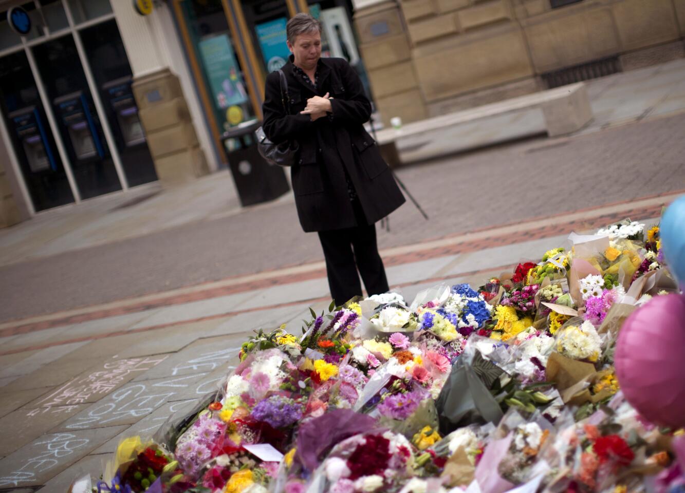 A woman stands May 24, 2017, near a memorial for the victims of the terror attack in Manchester, England.