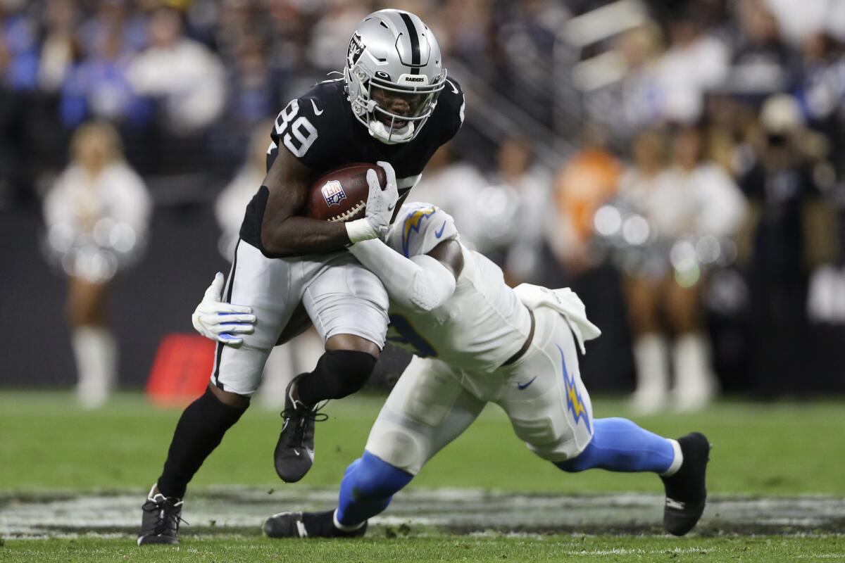 Los Angeles Chargers middle linebacker Kenneth Murray tackles Las Vegas Raiders wide receiver Bryan Edwards.