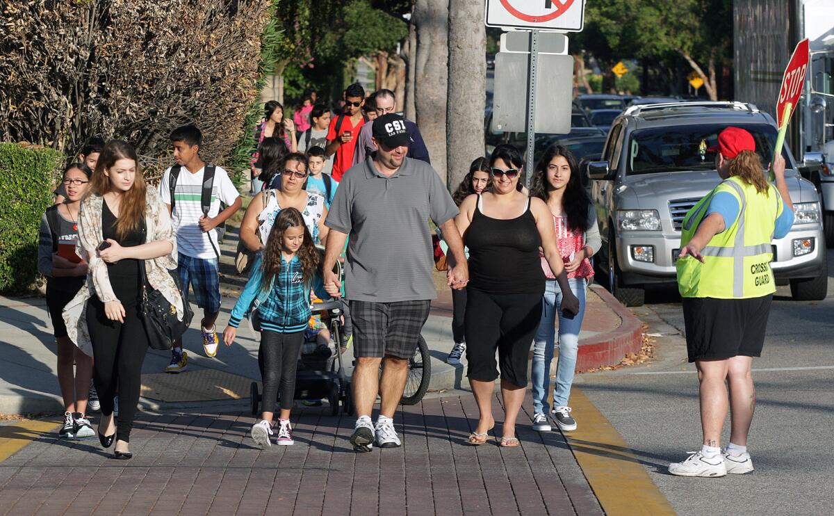 Parents and students of Toll Middle School, Mark Keppel Visual and Performing Arts Magnet School, and Hoover High School, cross Virginia Avenue in Glendale on the first day of school on Monday, August 11, 2014.