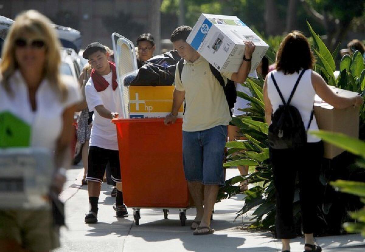 College students with boxes and carts move into their dorm rooms at UCLA.