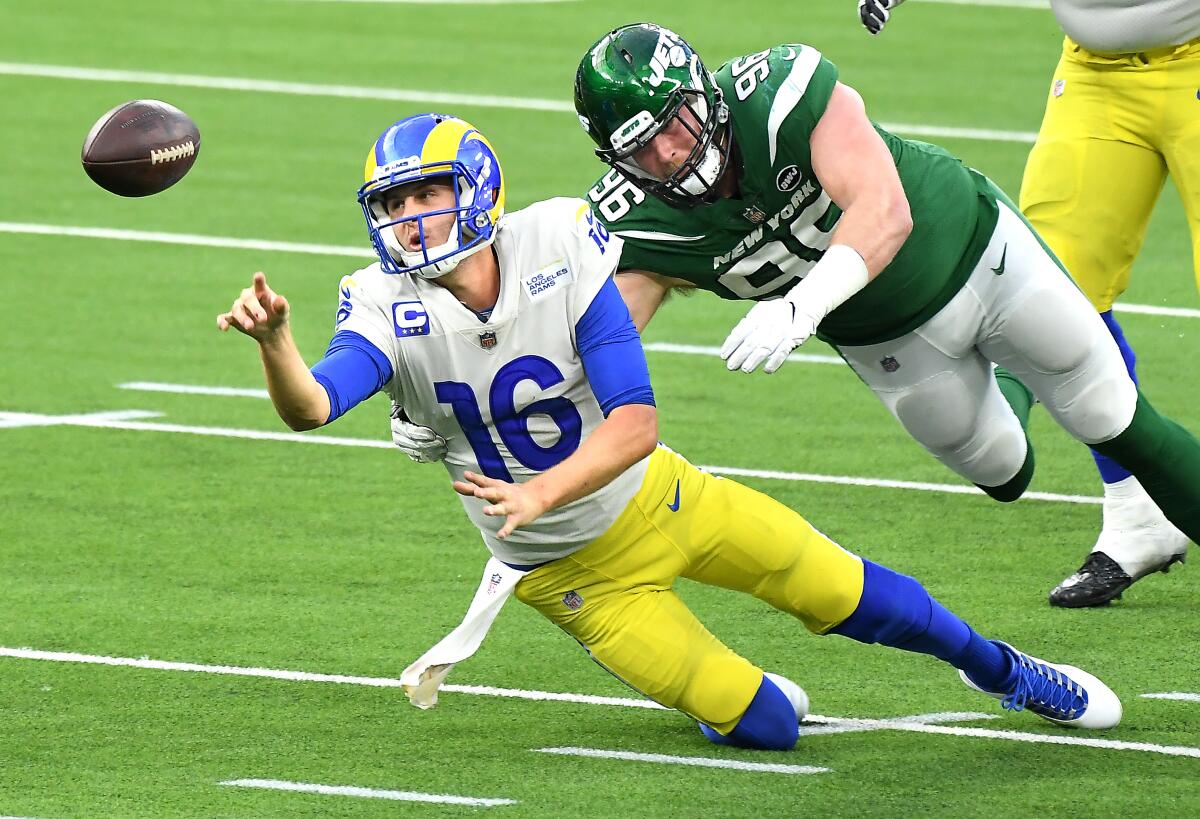 Rams quarterback Jared Goff unloads the ball before Jets defensive lineman Henry Anderson piles on.