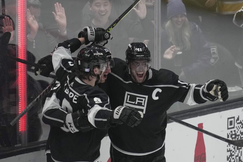Los Angeles Kings center Gabriel Vilardi (13) celebrates with center Adrian Kempe (9) and center Anze Kopitar (11) after scoring during the third period of an NHL hockey game against the Minnesota Wild Tuesday, Nov. 8, 2022, in Los Angeles. (AP Photo/Ashley Landis)