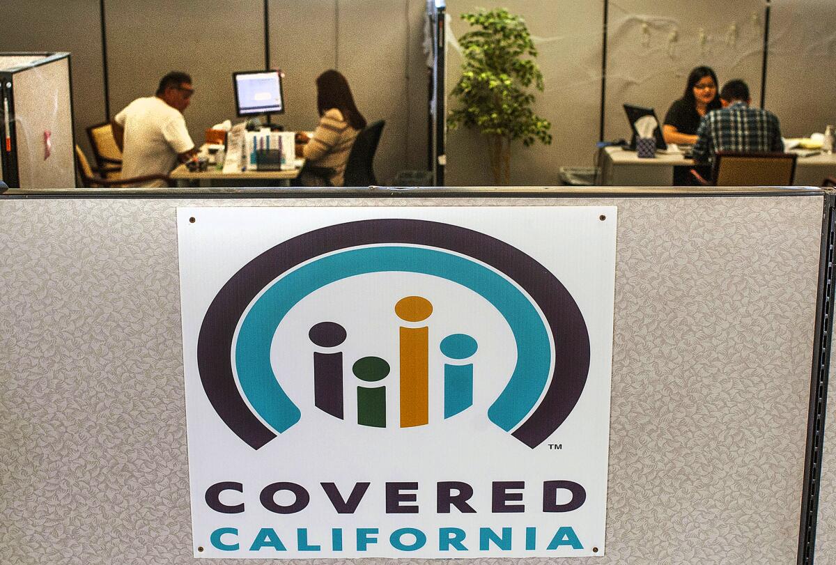 A Covered California sign on a cubicle wall