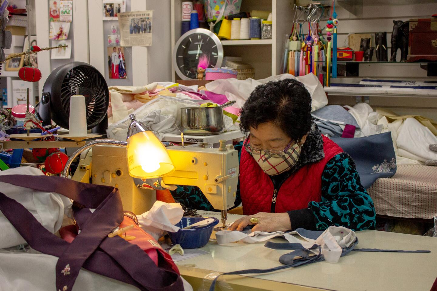 The store owner alters hanbok, traditional Korean clothing worn for celebrations, in her shop which is one a few in Orange County.