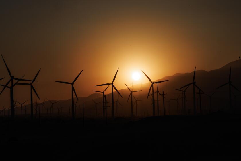 PALM SPRINGS, CA - JUNE 5, 2024: An orange glow fills the sky as the sun sets behind windmills on a triple digit temperature day on JUNE 5, 2024 in Palm Springs, California. (Gina Ferazzi / Los Angeles Times)