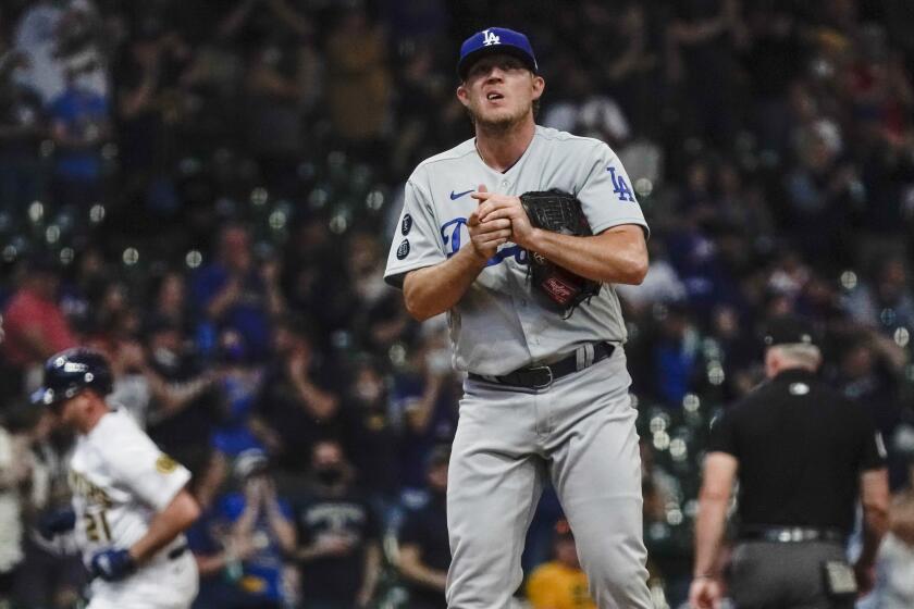 Los Angeles Dodgers' Garrett Cleavinger reacts after giving up a home run to Milwaukee Brewers' Travis Shaw.