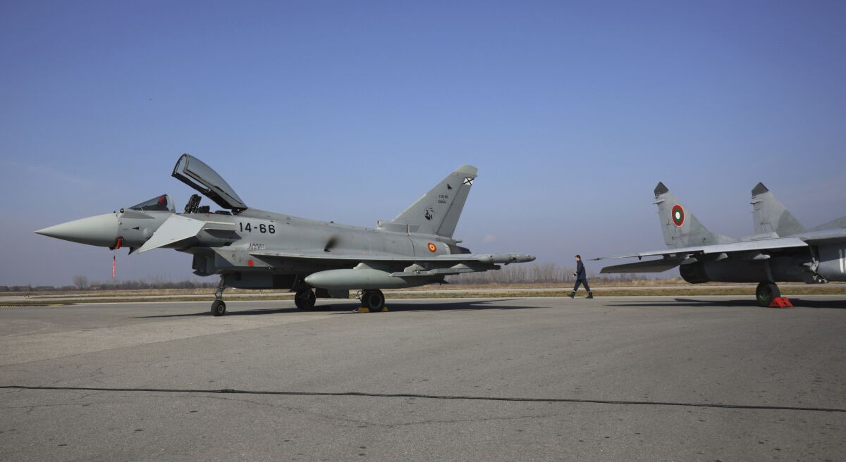 A Bulgarian MiG-29, right, and Spanish Eurofighter EF-2000 Typhoon II aircraft parked on airport tarmac