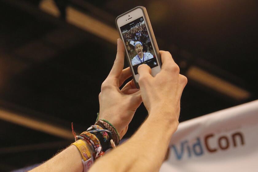 Ricky Dillon, a prolific and popular creator of YouTube comedy videos, takes a "selfie" photo in front of the hundreds of fans that came to meet him at the Anaheim Convention Center for the annual Vidcon event.