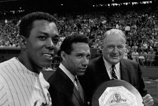 Three men stand on a baseball field