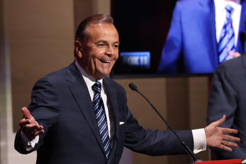 Rick Caruso gestures with open arms during the mayoral debate at USC on Tuesday.