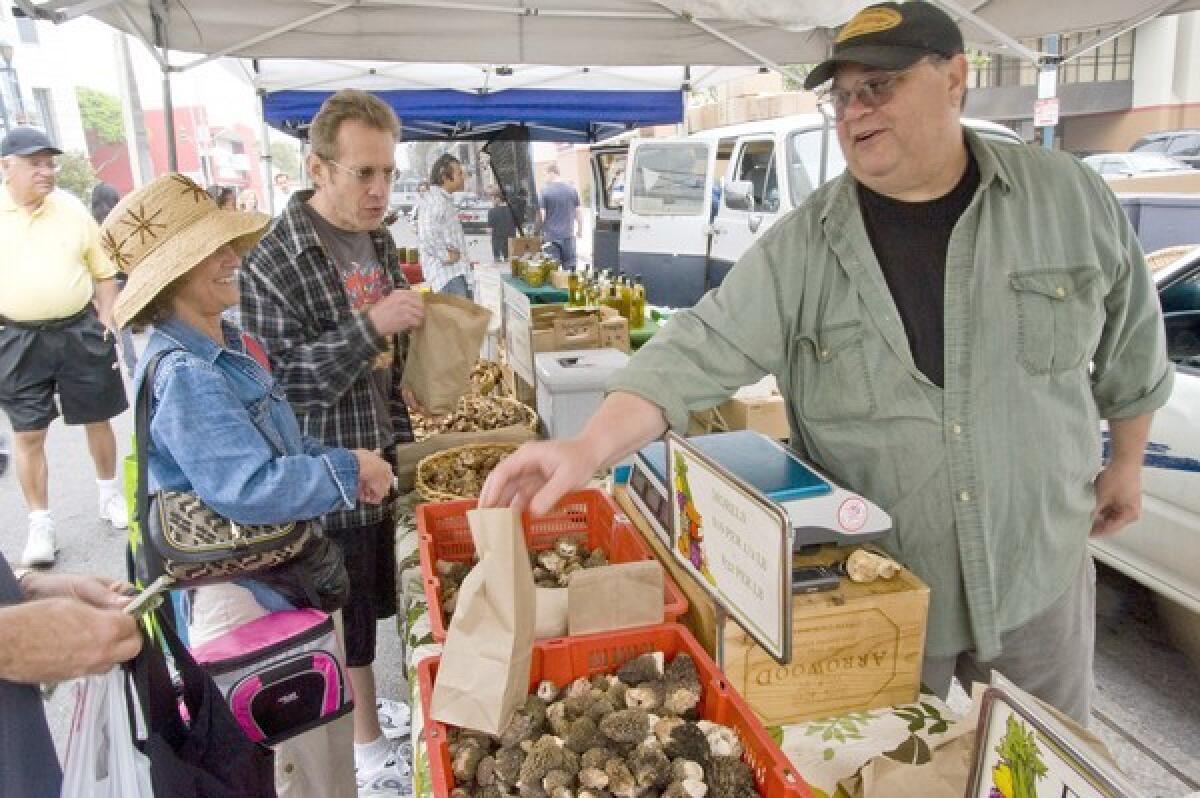 David West sells wild porcini and morel mushrooms gathered from the mountains near the California- Oregon border, at the Santa Monica Saturday farmers market.