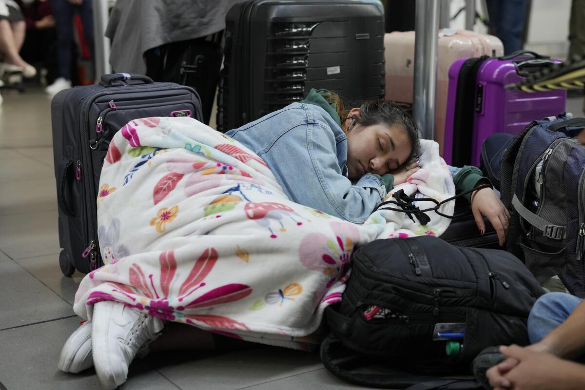 Una pasajera de Viva Air duerme junto a sus maletas 