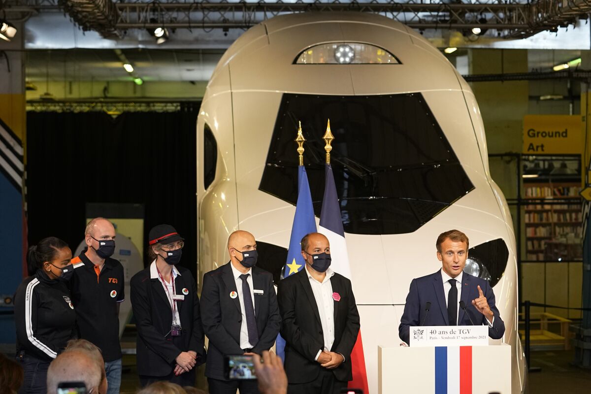French President Emmanuel Macron speaks in front of a life-size replica of the next high-speed train TGV, at the Gare de Lyon station Friday, Sept. 17, 2021 in Paris. France unveils a super-fast, climate-friendly train of the future, the next generation of its high-speed TGV trains that have been emulated around the world. French President Emmanuel Macron and other government officials are holding a ceremony at the historic Gare de Lyon train station in Paris to mark 40 years since the unveiling of the first TGV, or "train a grand vitesse." (AP Photo/Michel Euler, Pool)