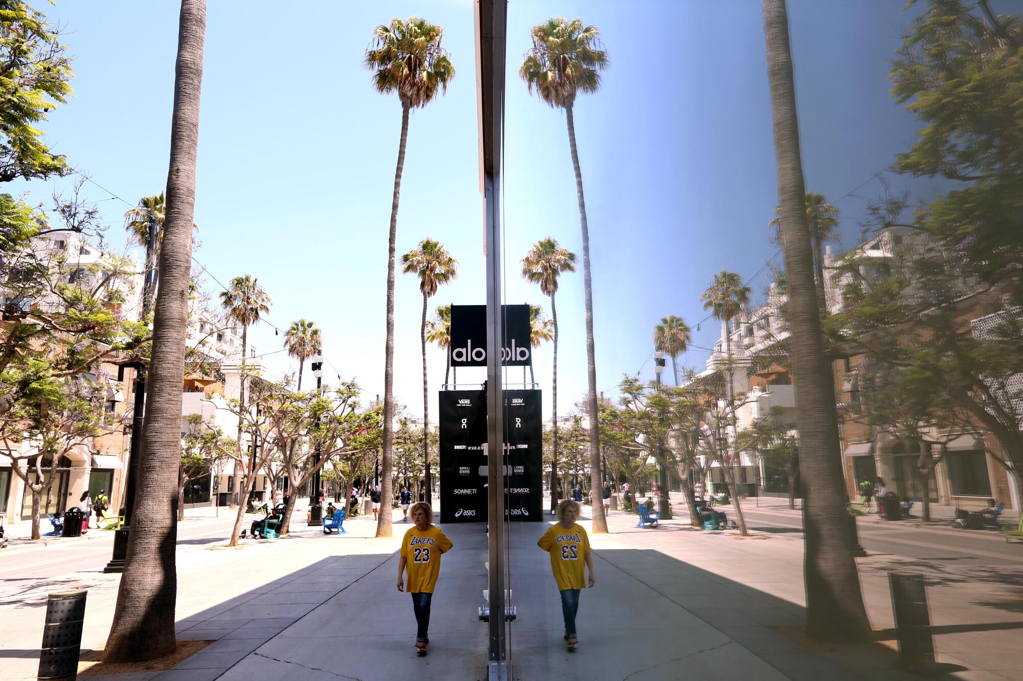 A passing shopper is reflected in the  window of a vacant store on the Third Street Promenade in Santa Monica.