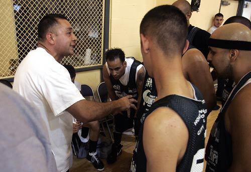 Coach Manny Panduro speaks to a Latino team from Wilmington playing in the Moonlight league basketball tournament at Nickerson Gardens in Watts. The players had to prove themselves if they wanted to win respect from opposing players and spectators  most of whom were African American.