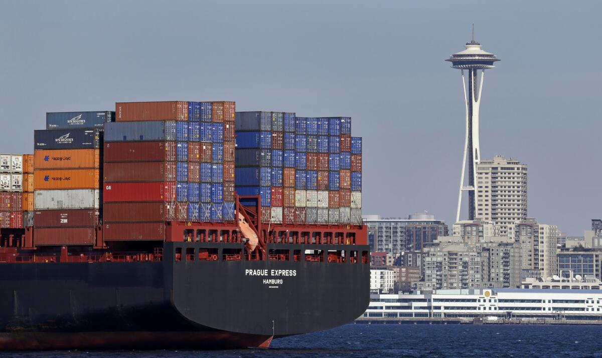 2015年2月15日，集装箱船停在西雅图市中心附近的艾略特湾，旁边的背景是太空针塔。