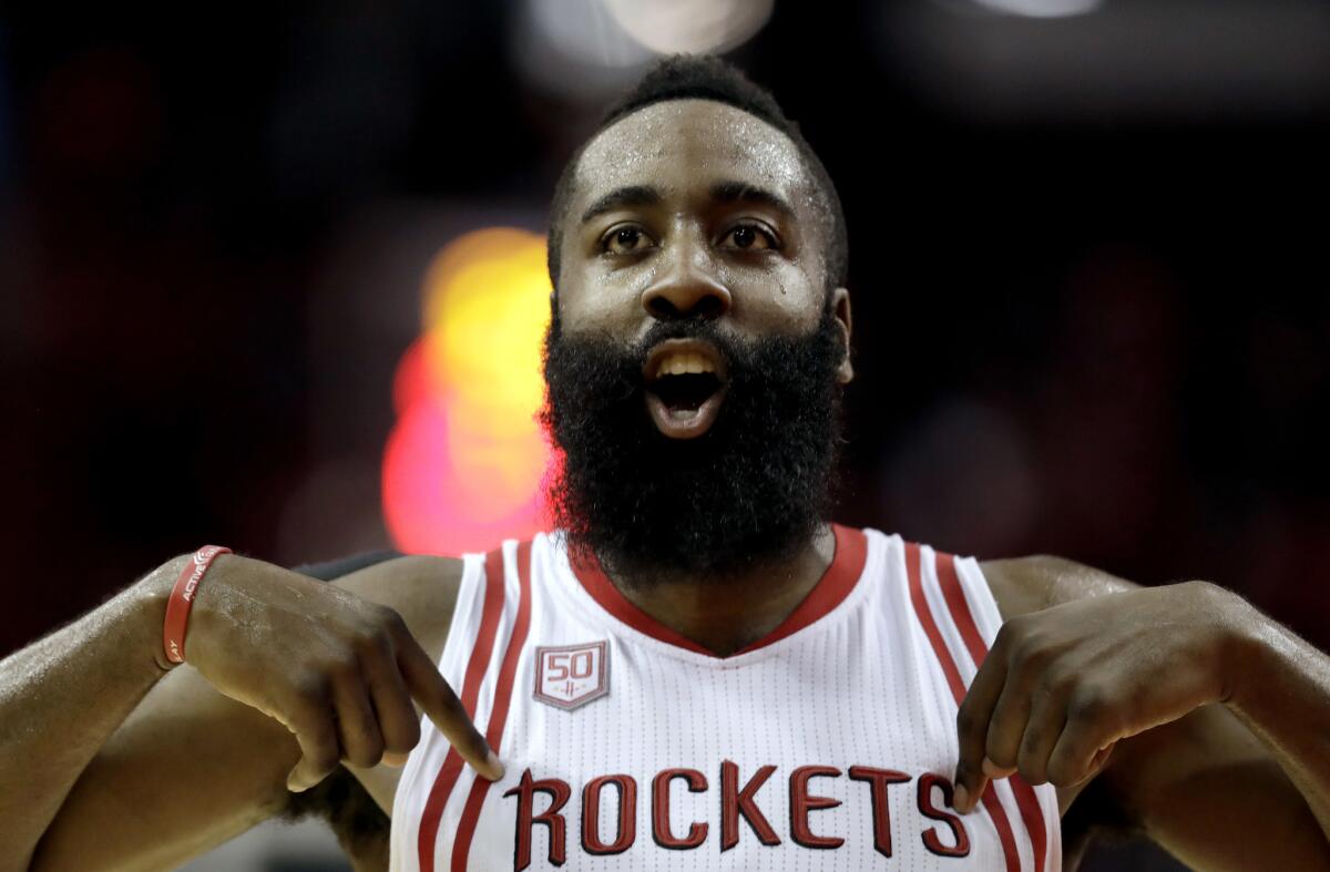 Rockets star James Harden encourages the fans after scoring a basket during the second half against the Boston Celtics on Dec. 5.