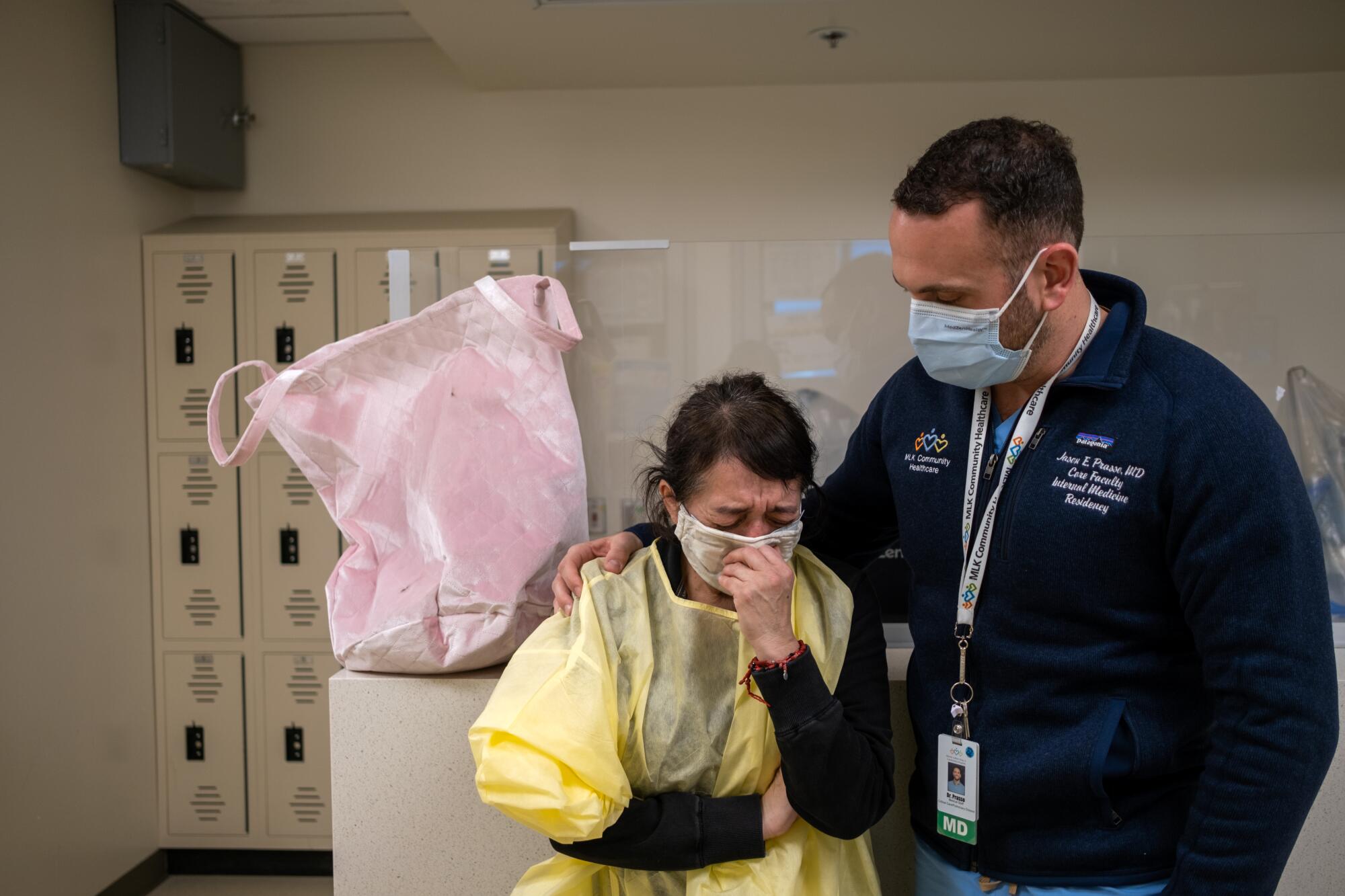 Elena Padilla, left, begins to cry as she speaks with Dr. Jason Prasso, right, inside the ICU at MLK Community Hospital. 