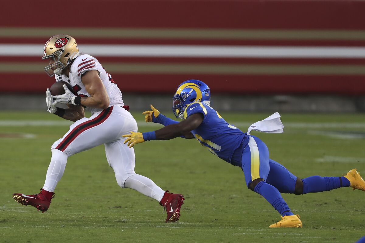 San Francisco 49ers tight end George Kittle catches a pass in front of Rams defensive back Darious Williams.