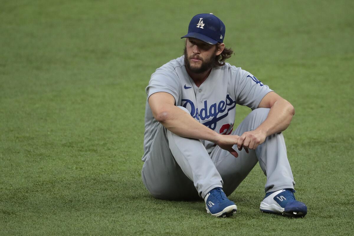 Clayton Kershaw stretches in the outfield before taking on the Braves in game four of the NLCS at Globe Life Field. 