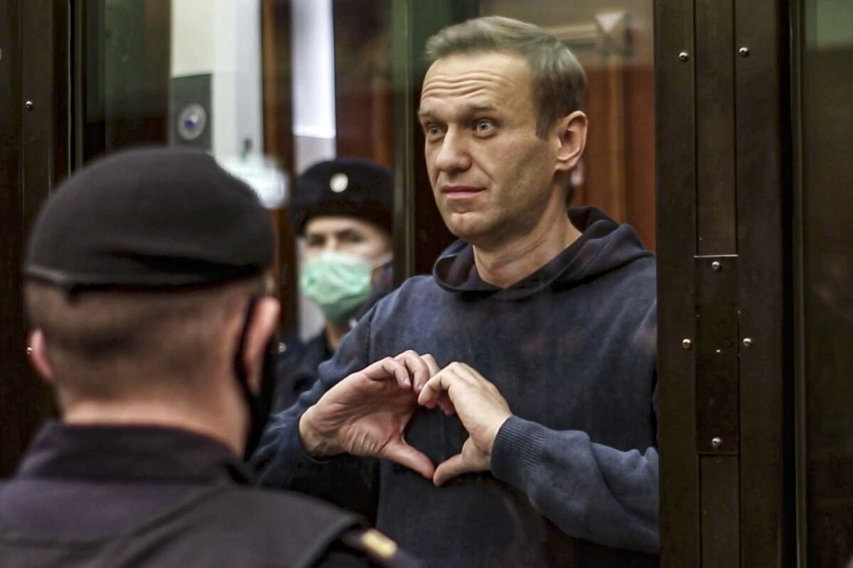 Alexei Navalny makes a heart symbol with his hands in Moscow court. 