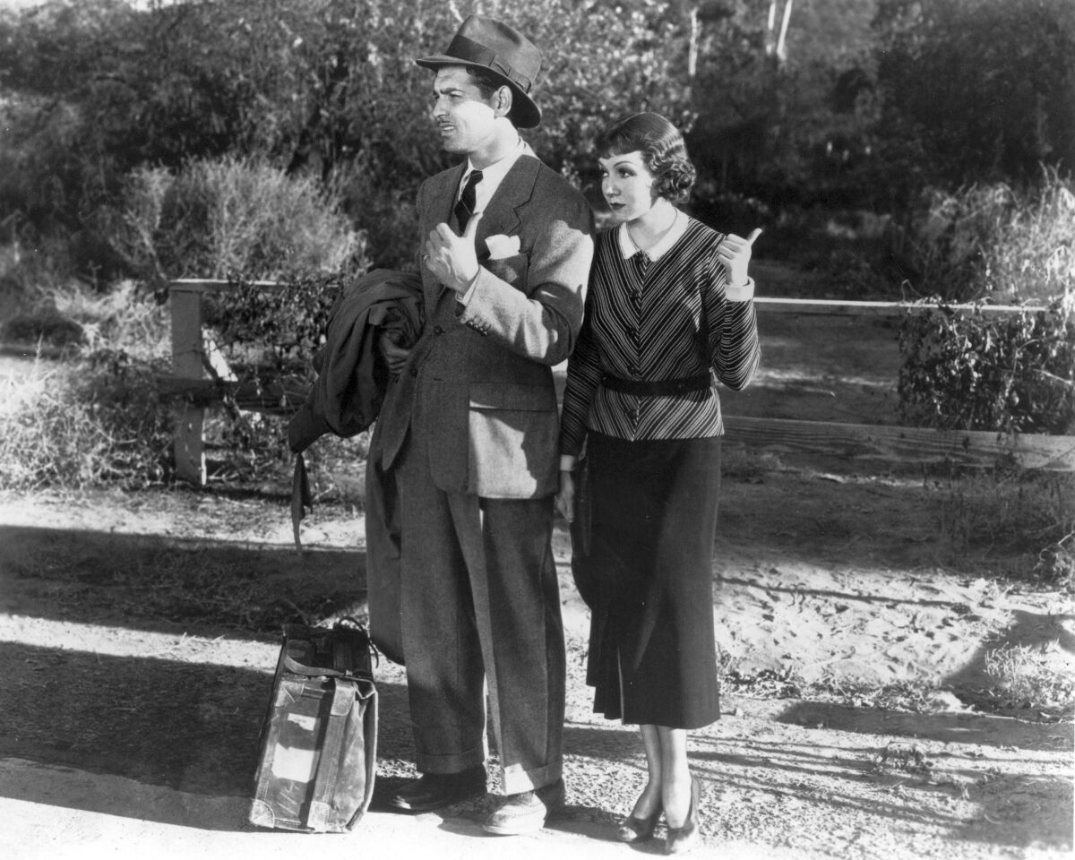 Clark Gable and Claudette Colbert hitchhiking in a scene from the movie "It Happened One Night" (1934) 