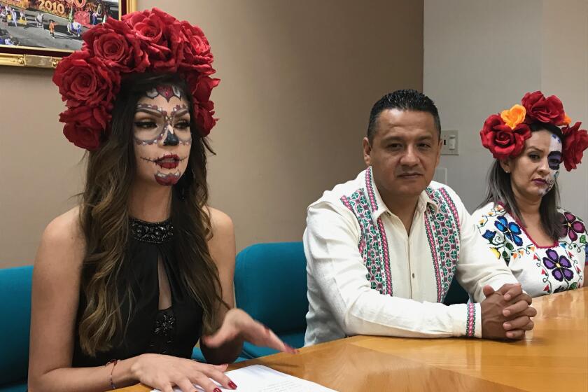 Gema del Río Ambriz (izquierda), presidenta honoraria del DIF municipal, llegó vestida alusiva al Festival de Velas. Al centro, aparece Alejandro Mejía, secretario particular del presidente municipal de Uruapan.