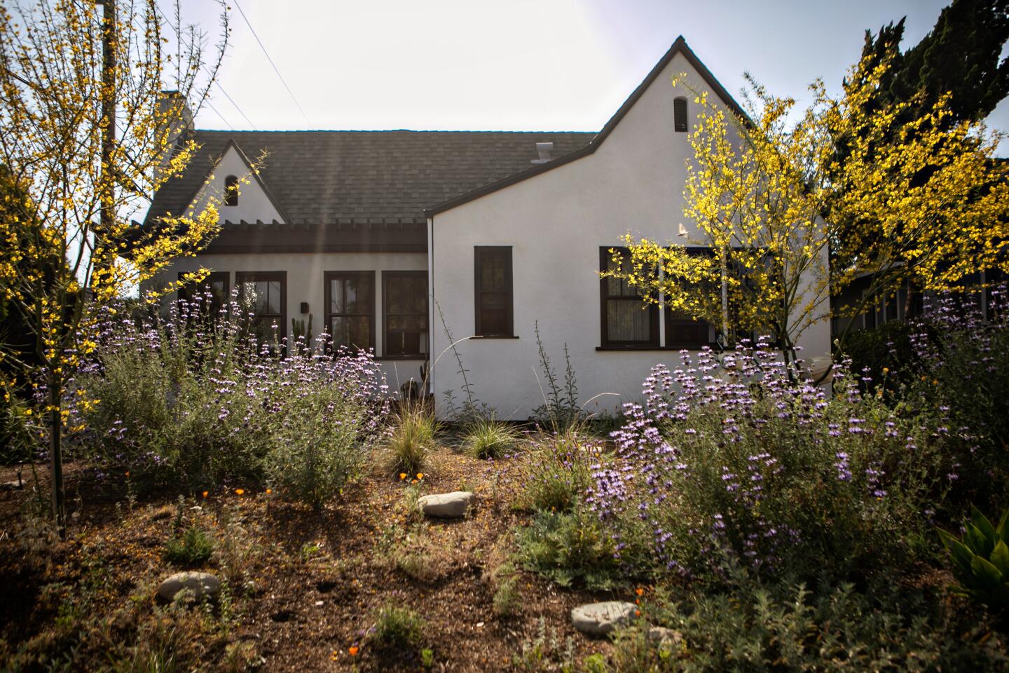 The front yard of a  black and white Tudor home 