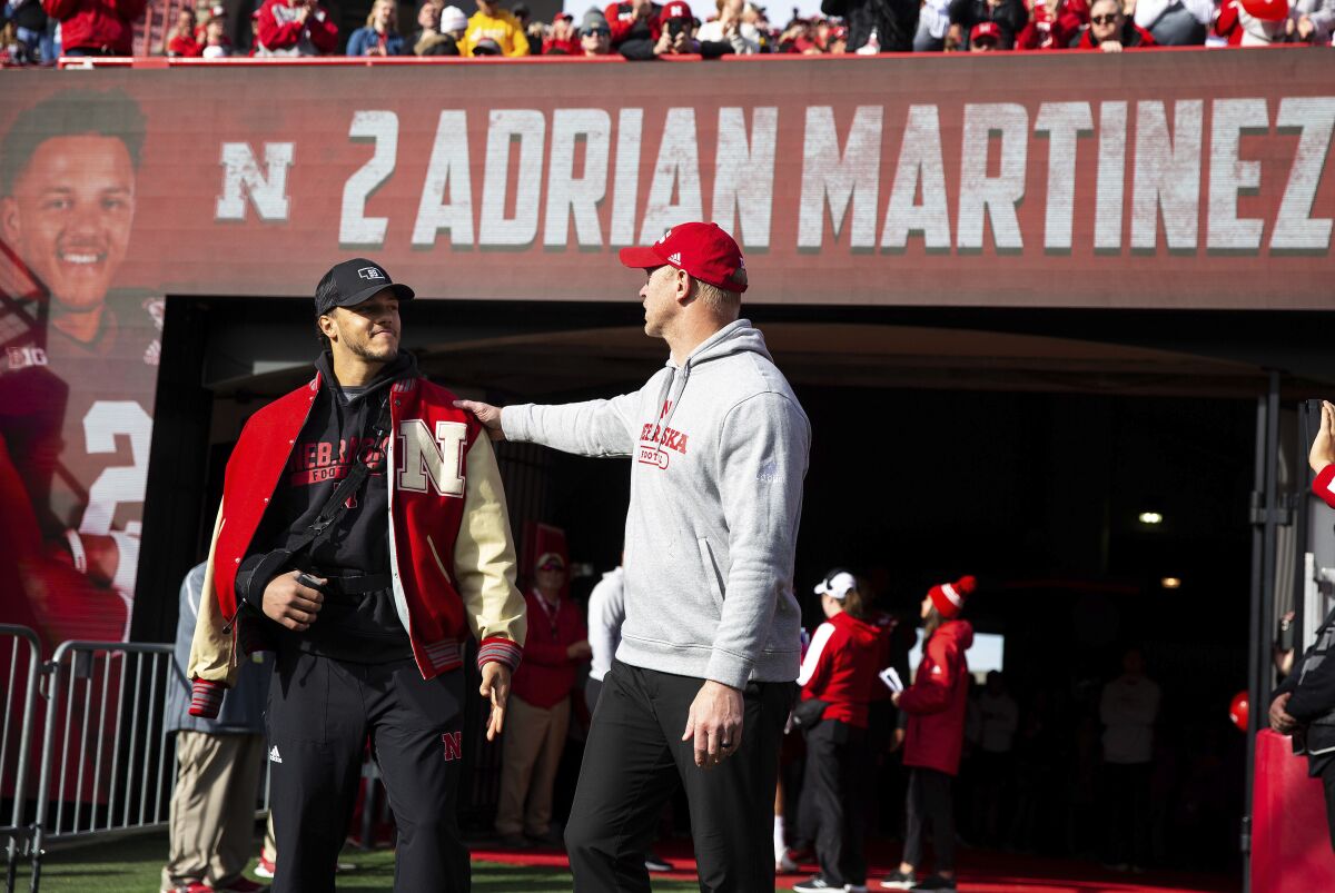 Nebraska head coach Scott Frost acknowledges four-year starting quarterback Adrian Martinez (2) during senior day before playing against Iowa during an NCAA college football game Friday, Nov. 26, 2021, at Memorial Stadium in Lincoln, Neb. Martinez did not play the game due to injury. (AP Photo/Rebecca S. Gratz)