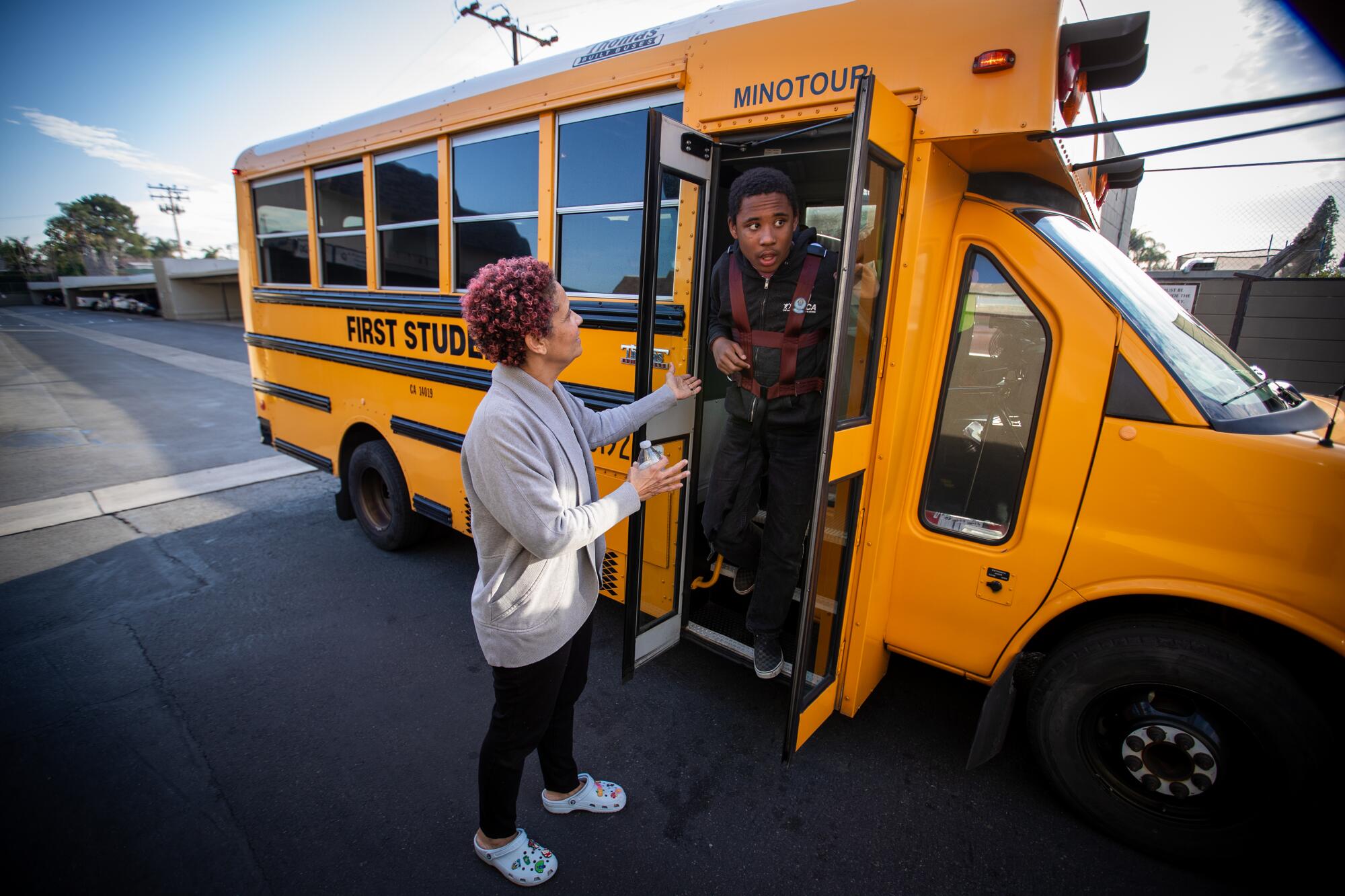 Christine LyBurtus greets son Noah as he arrives home on a bus