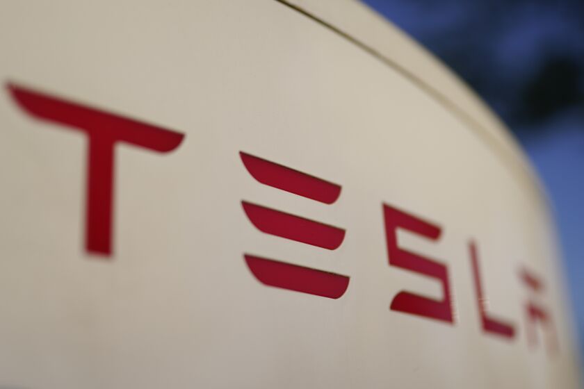 FILE - A Tesla Supercharger station in Buford, Ga., is pictured on April 22, 2022. Tesla's 2022 second-quarter profit fell 32% from record levels in the first quarter as supply chain issues and pandemic lockdowns in China slowed production of its electric vehicles. (AP Photo/Chris Carlson)