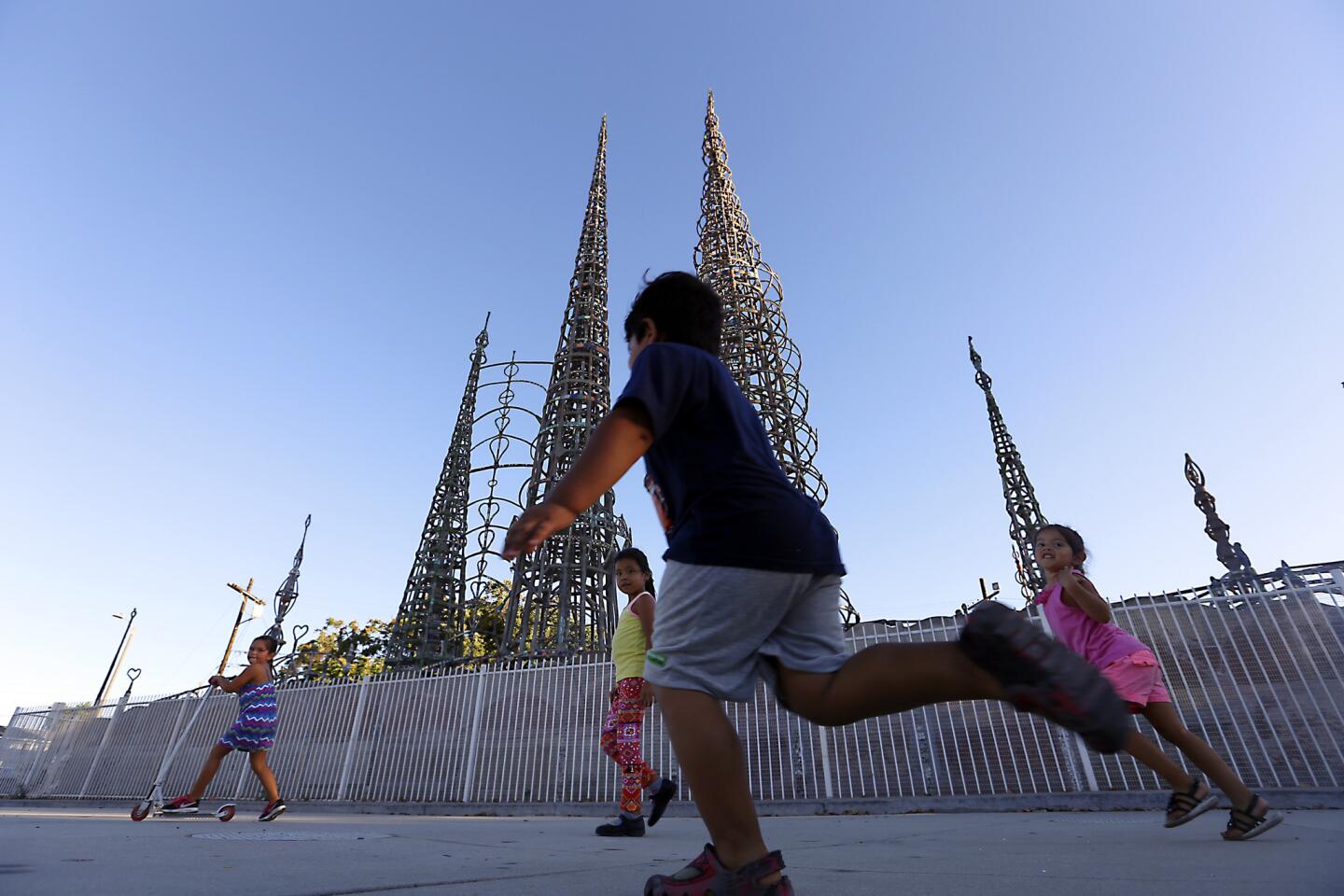 Children play in front of the Watts Towers on Aug. 5, 2015. The average per-square-foot price for housing in the south Los Angeles neighborhood of Watts ($212) is similar to Stapleton in Staten Island ($198).