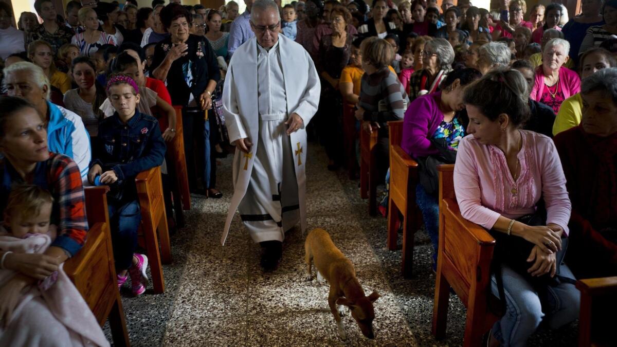Father Cirilo Castro walks down the aisle of the newly inaugurated Parish of the Sacred Heart of Jesus in Sandino, Cuba, on Saturday.