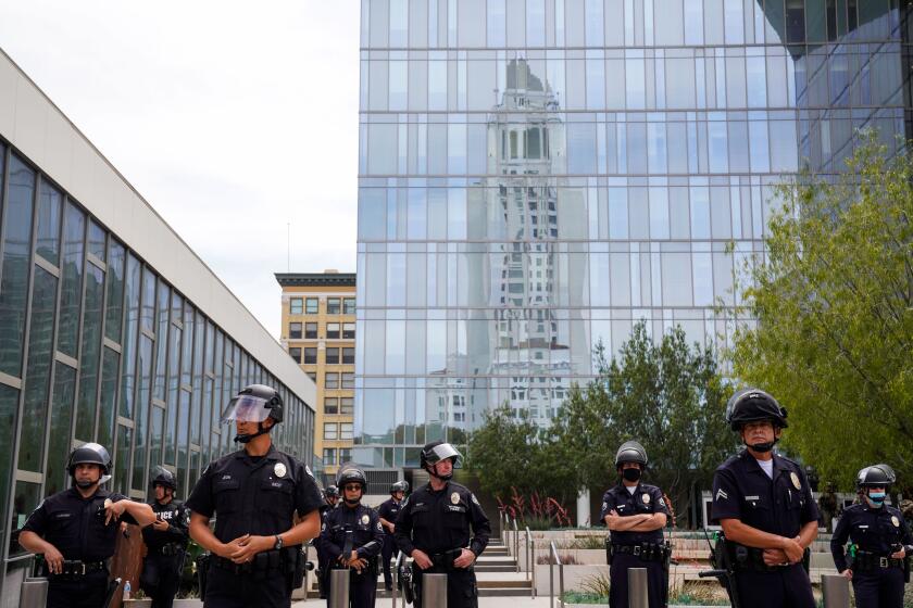 LOS ANGELES, CA - JUNE 02: Law enforcement personnel stand in front of LAPD HQ as demonstrators chant in downtown Los Angeles on Tuesday, June 2, 2020 in Los Angeles, CA. Protests have erupted across the country, with people outraged over the death of George Floyd, a black man killed after a white Minneapolis police officer pinned him to the ground with his knee. (Kent Nishimura / Los Angeles Times)