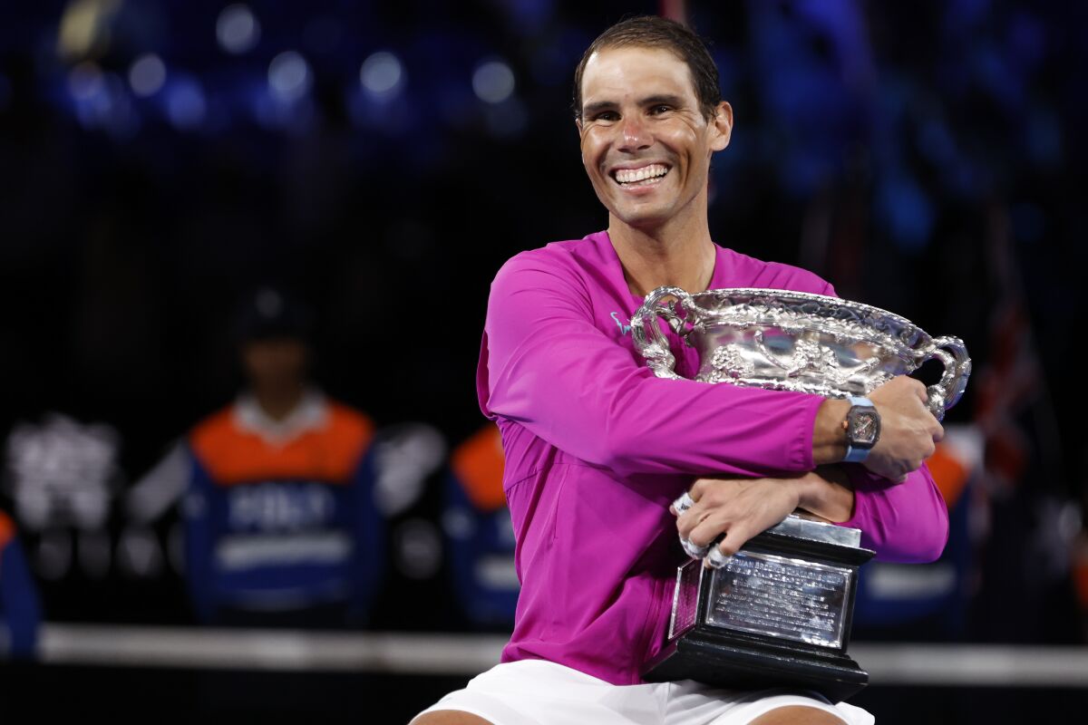 Rafael Nadal of Spain embraces the Norman Brookes Challenge Cup after defeating Daniil Medvedev of Russia in the men's singles final at the Australian Open tennis championships in Melbourne, Australia, early Monday, Jan. 31, 2022. (AP Photo/Hamish Blair)