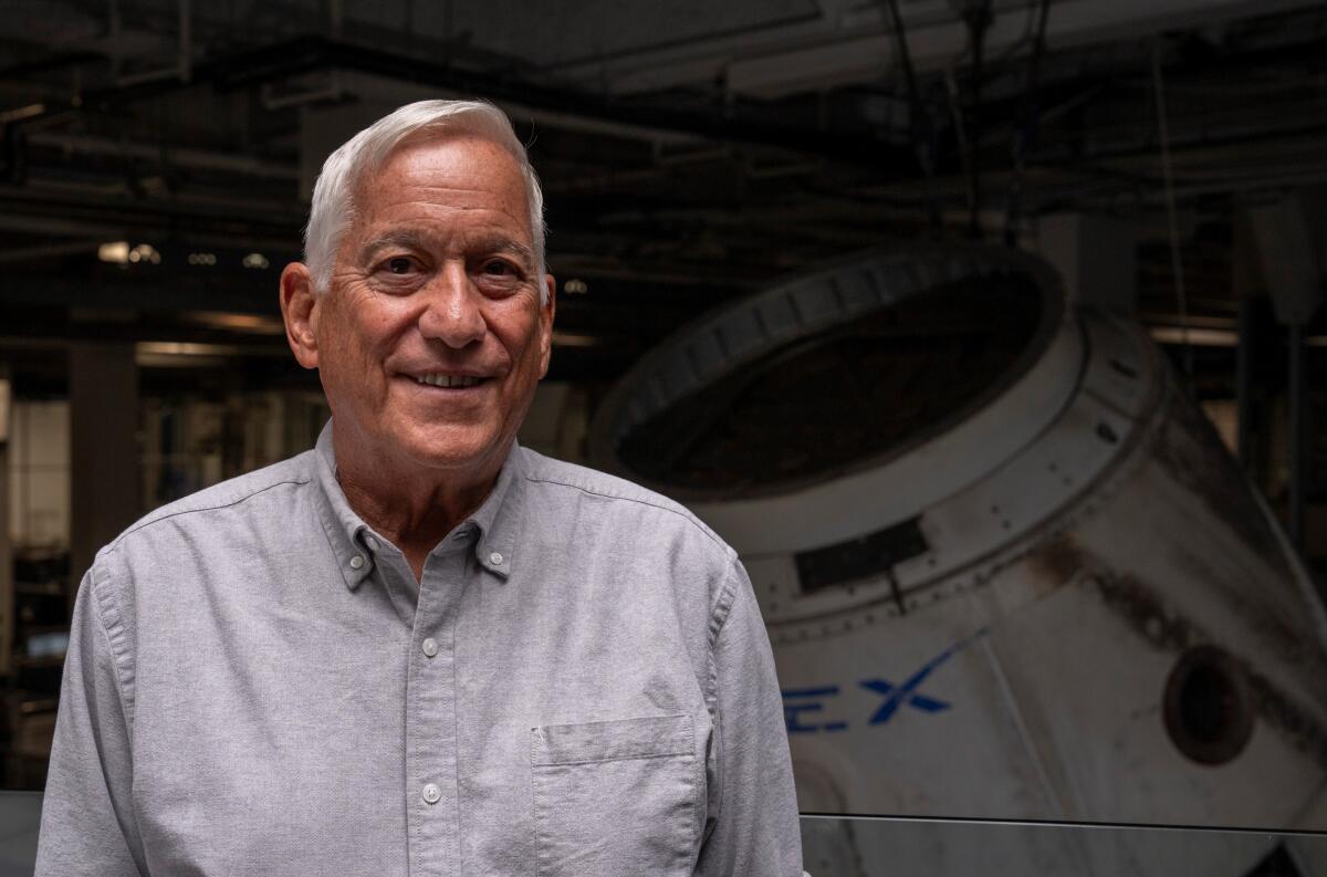 A smiling man with gray hair in a button-down shirt.