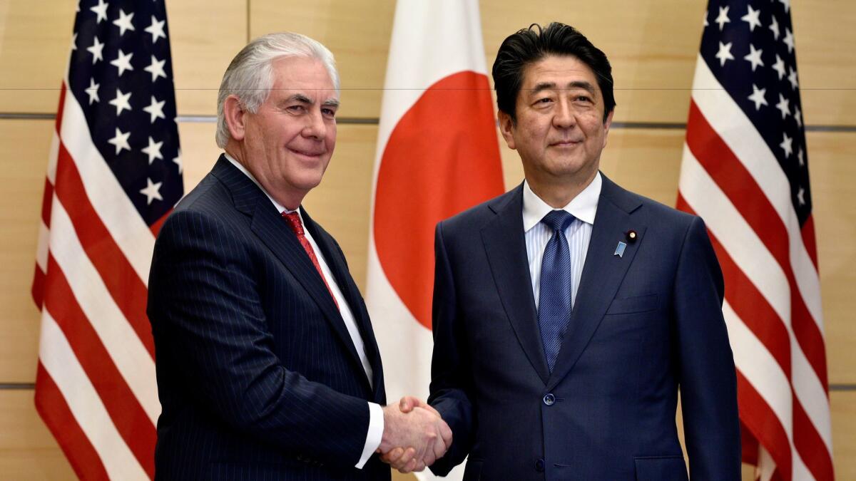 U.S. Secretary of State Rex Tillerson, left, shakes hands with Japanese Prime Minister Shinzo Abe at the start of their meeting in Tokyo on March 16, 2017.