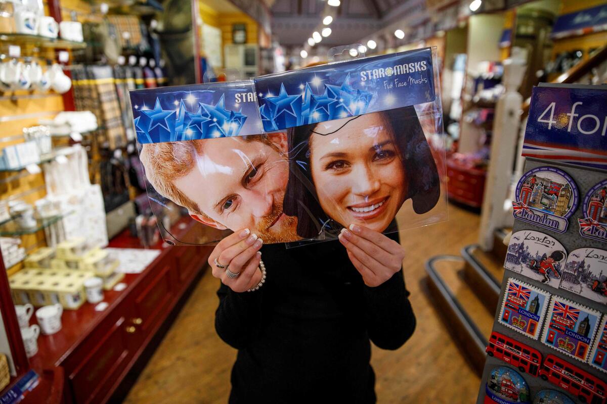 April 1, 2018: A shopkeeper holds souvenirs featuring Prince Harry and fiance Meghan Markle, the American actress.