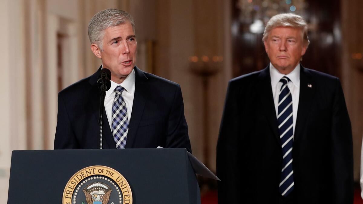 Judge Neil Gorsuch speaks as President Donald Trump stands beside him in the East Room of the White House on Jan. 31.