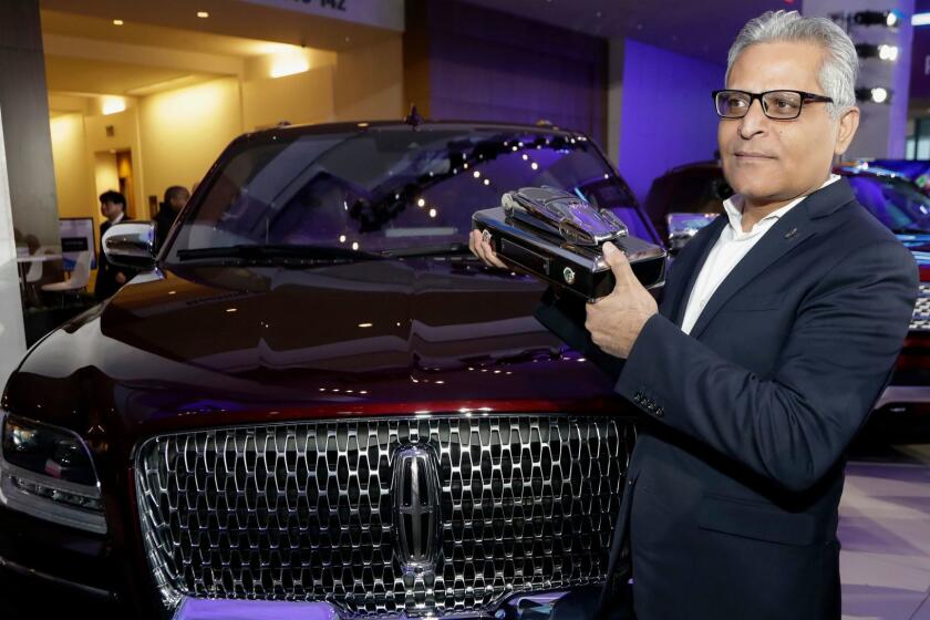 FILE- In this Jan. 15, 2018, file photo, Kumar Galhotra, group vice president for Lincoln stands next to the 2018 Lincoln Navigator after the vehicle won truck of the year during the North American International Auto Show in Detroit. Ford Motor Co. said Thursday, Feb. 22, that it is naming Galhotra as a replacement for Raj Nair, the president for North America who was ousted this week over allegations of inappropriate behavior. Galhotra will take over on March 1. (AP Photo/Carlos Osorio, File)