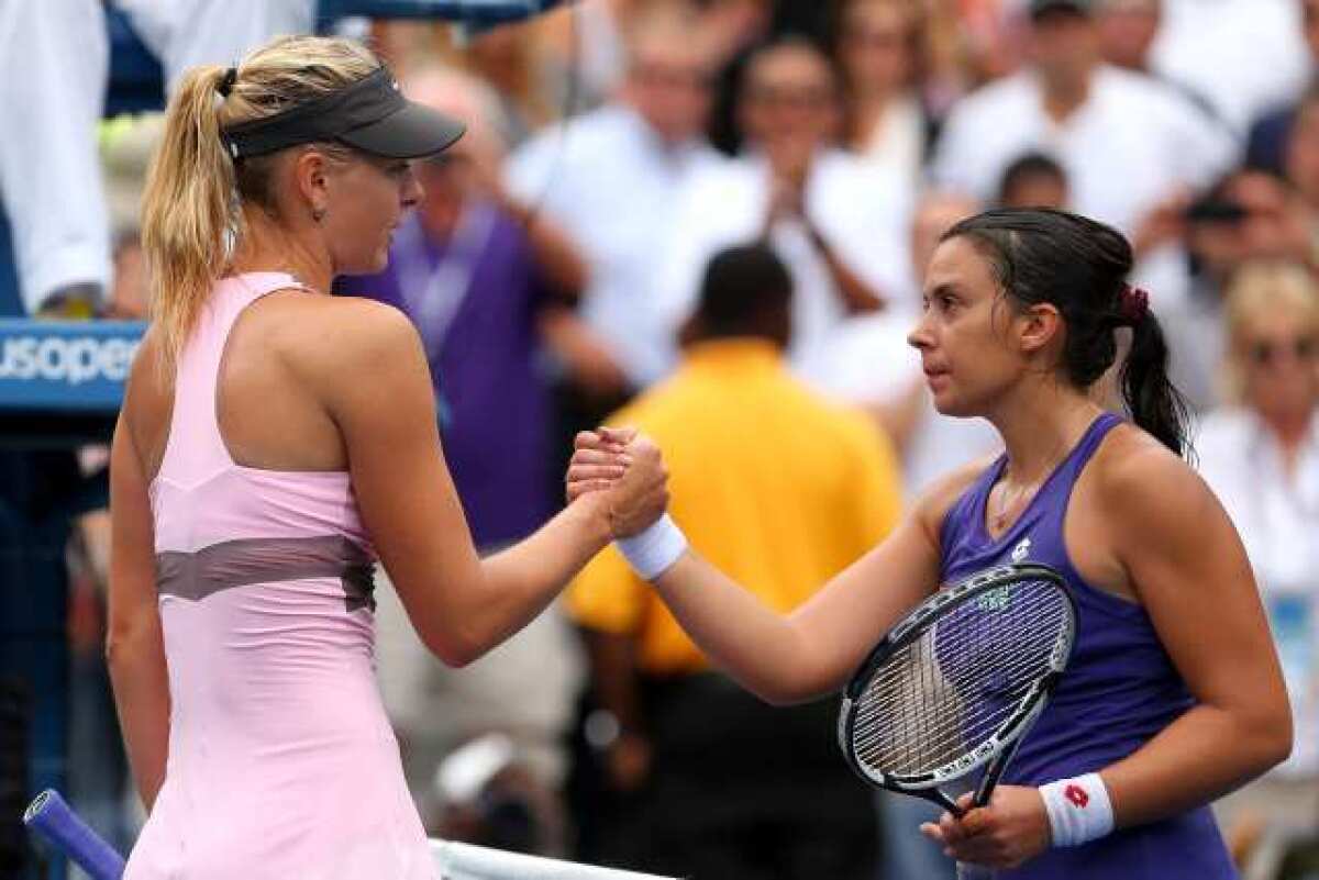 Maria Sharapova, left, shakes hands with Marion Bartoli after their match at the U.S. Open in New York.