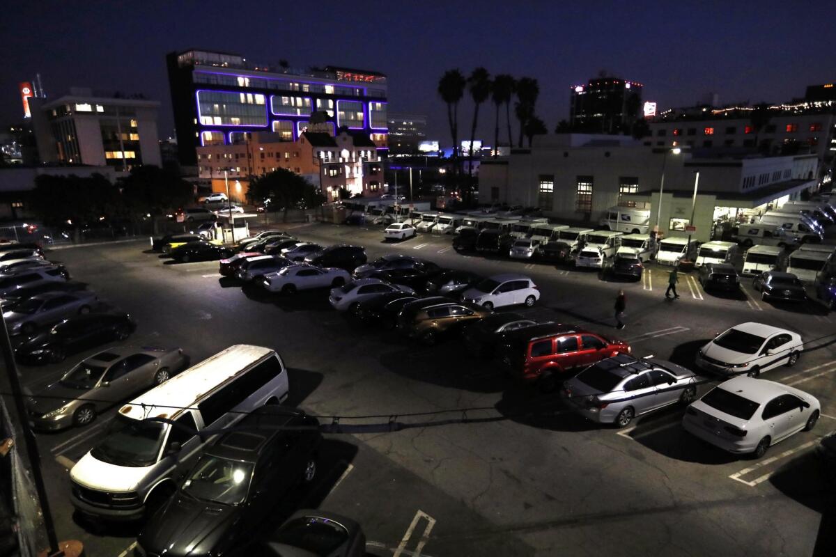 Two men walk through the parking lot at 1637 North Wilcox Avenue in Hollywood. Safran & Associates, a for-profit developer of affordable housing, has been selected to develop the lot which rests across the street from the high-end Dream Hollywood hotel.