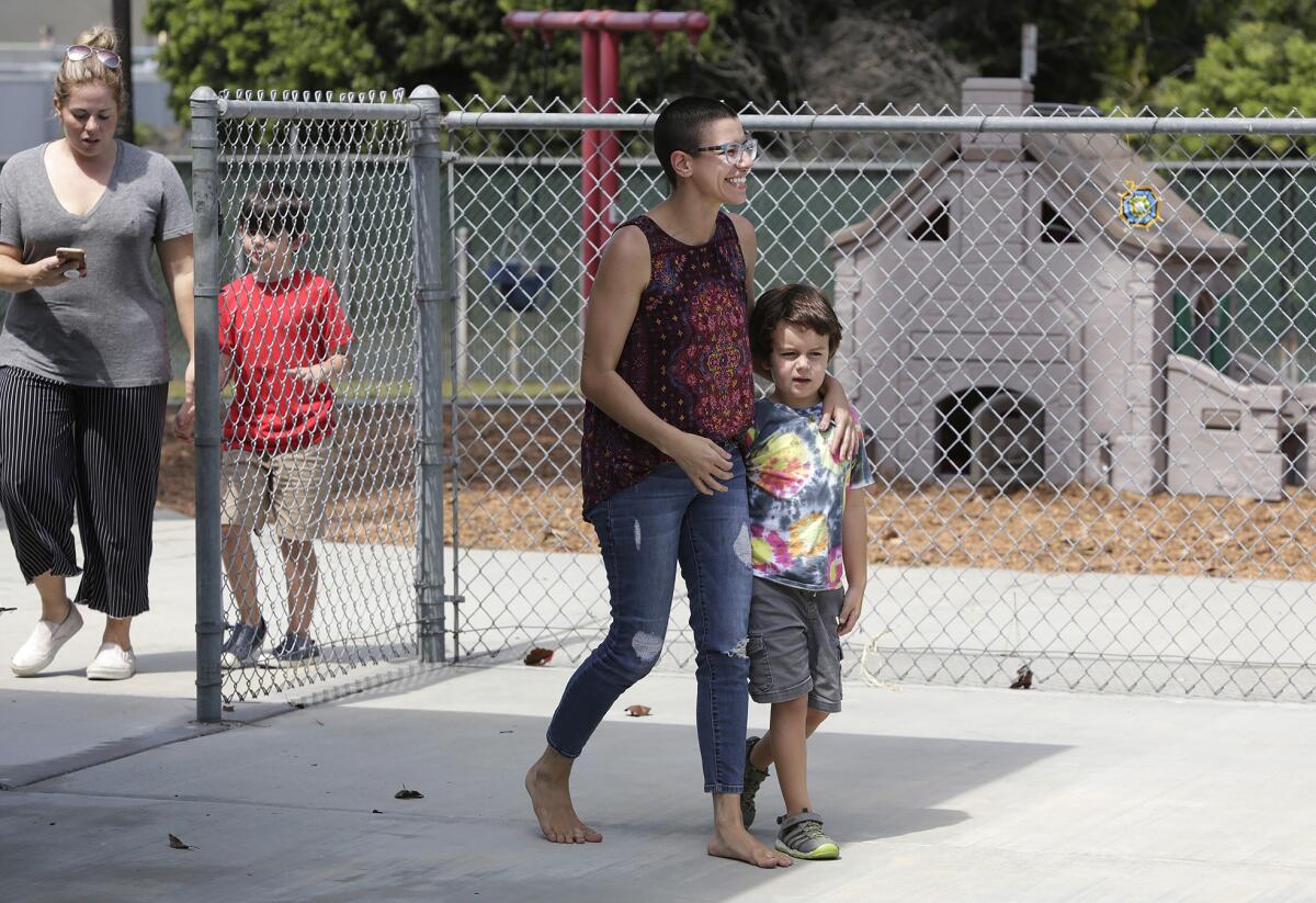 Riss Mahaffey walks with her son, Bronson, 6, at the new Sycamore Creek Community Charter School in Huntington Beach on Thursday.