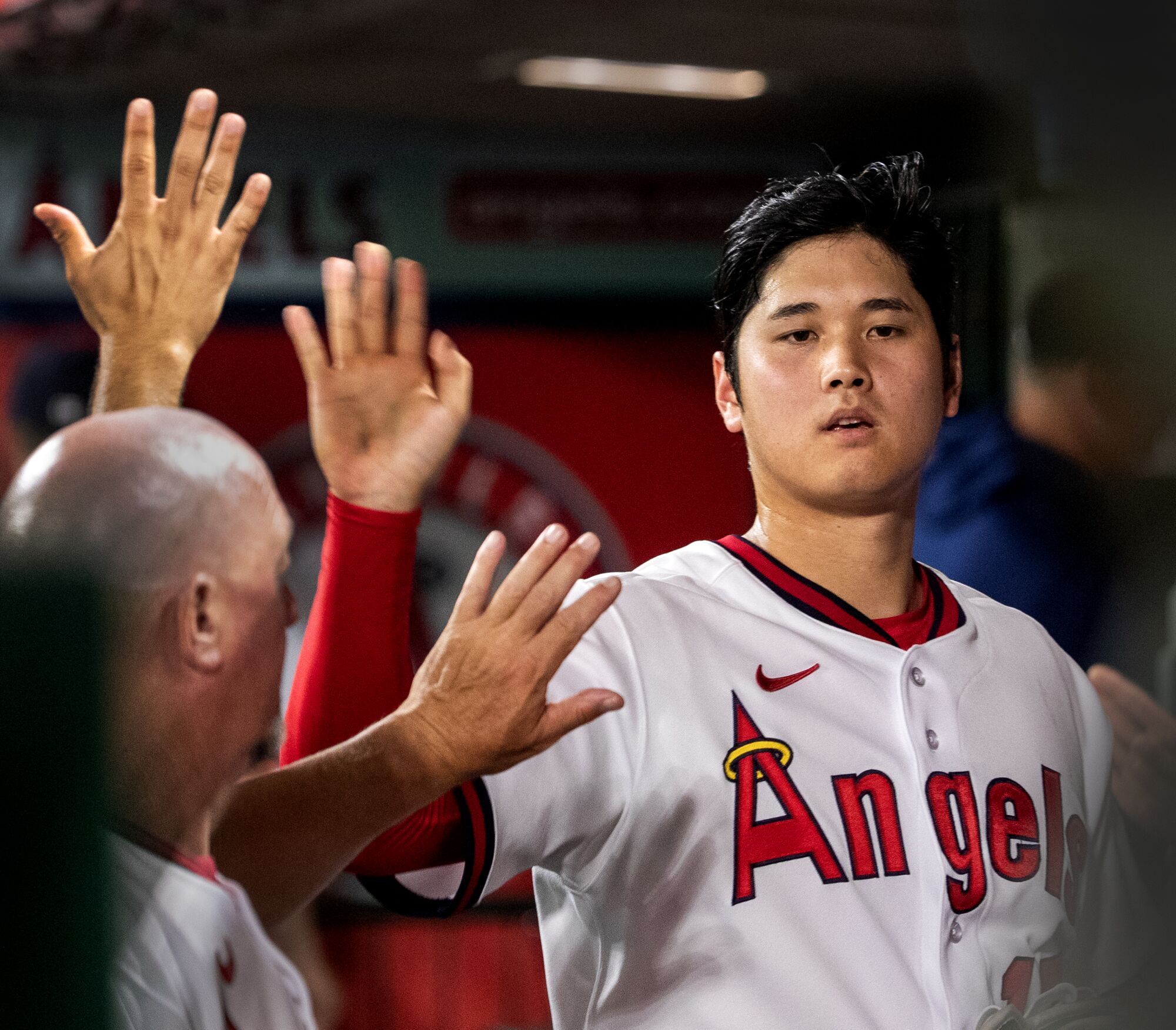 Angels starting pitcher Shohei Ohtani is congratulated by teammates in the dugout 