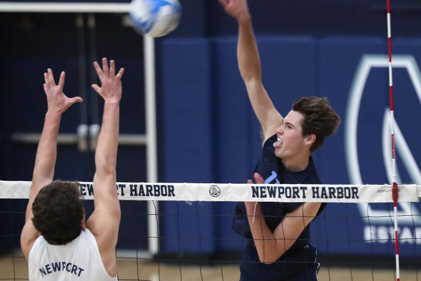 Sterling Foley (11) of Corona del Mar puts a kill away during Battle of the Bay, Surf League match-up against Newport Harbor on Wednesday.