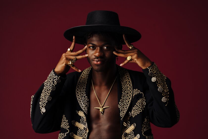 Lil Nas X poses for a portrait in cowboy-themed attire.