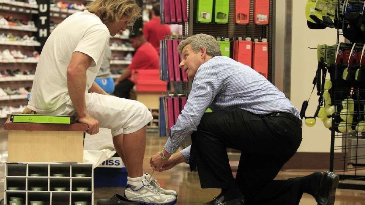 Craig Levra, right, helps a customer in 2011 when he was chief executive of the now-shuttered Sport Chalet. Levra has been named president of Gear Coop, a sporting goods company based in Costa Mesa.