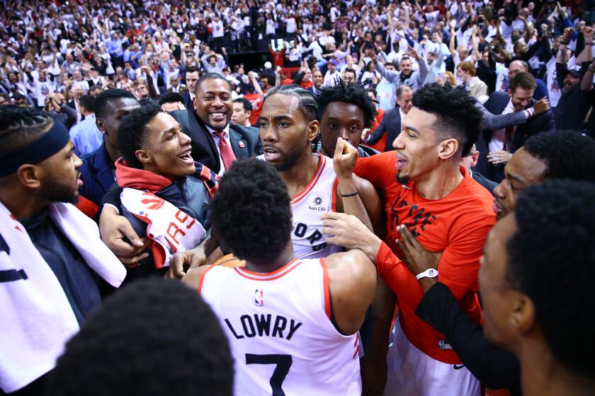 Raptors forward Kawhi Leonard is surrounded by his teammates after hitting a buzzer beater to win Game 7 of a playoff series against the 76ers on May 12.